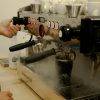 Taza térmica Chela Thermal black llenandose en la máquina de la cafetería